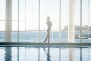 una mujer caminando frente a una piscina en Støtvig Hotel, en Moss