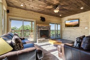 セバービルにあるAdventure Splash - Smoky Mountain Retreats Cabins with Private Indoor Pool, Hot Tubs & Fun!のソファと暖炉のあるリビングルーム