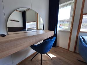 a dressing table with a mirror and a blue chair at Tjeldsundbrua Hotel in Evenskjer