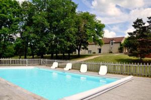 einen Pool mit Stühlen und einem Zaun in der Unterkunft les gîtes de fred en Dordogne, Maisons avec piscines privées et chauffées in Florimont-Gaumiers
