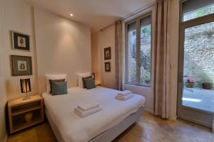 a bedroom with a bed with white sheets and a window at La Maison du Puits with wood-burning stove Honfleur center 5P in Honfleur