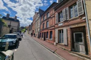 a street with buildings and a car parked on the street at La Maison du Puits with wood-burning stove Honfleur center 5P in Honfleur