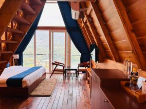 1 dormitorio con cama y ventana grande en The Lake Ambience Resort, en Bhimtal