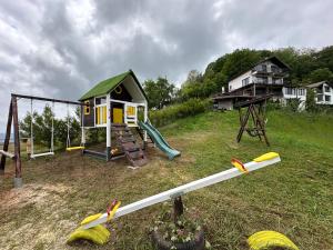 un parco giochi con una piccola casa e un'altalena di Karadzhovata Kashta a Zlatograd