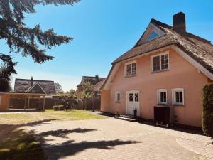 Ferienhaus Fiete in Wieck في ويك: منزل وردي مع سقف