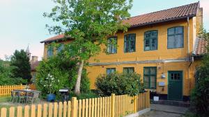 una casa amarilla con una valla delante de ella en Sonnige Ferienwohnung I, en Harrislee
