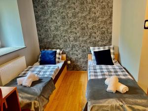 two beds in a room with a laptop on them at Tanie Noclegi Puszkina 2 in Wałbrzych