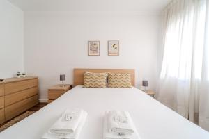 a white bedroom with a large white bed and curtains at Norton Matos - T2 in the heart of Braga by House and People in Braga