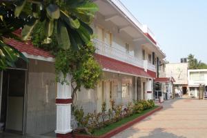 ein Gebäude mit Pflanzen an der Straßenseite in der Unterkunft Le Radha Grand in Mahabalipuram