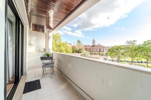 a balcony with a chair and a view of a building at Norton Matos - T2 in the heart of Braga by House and People in Braga