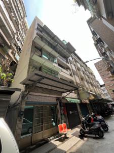 a building with two motorcycles parked in front of it at Nobiggie lnn in Kaohsiung