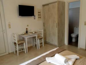 a bedroom with a bed and a table and a bathroom at Lady S Holiday Studio in Lampi