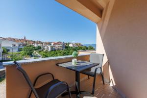 einen kleinen Tisch und Stühle auf einem Balkon mit Aussicht in der Unterkunft Beachfront Apartment Betty - Happy Rentals in Vrbnik