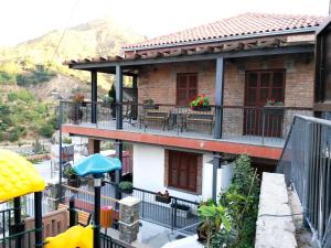 Casa con balcón con mesas y sillas en Archontiko I Misirlou en Kalopanayiotis