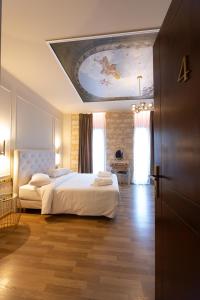 a bedroom with two beds and a painting on the ceiling at L Suites The Writer's House in Gythio +120 photos