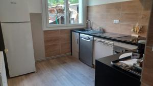 a kitchen with a refrigerator and a counter top at VILLARGONDRAN, les lacets Mauriennais, garage motos, vélos in Villargondran