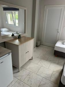 a bathroom with a vanity and a mirror and a bed at Marele Hills Boutique Apartments in Nea Fokea