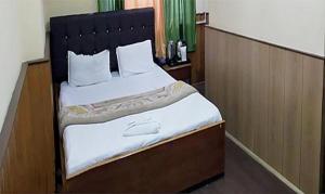 1 dormitorio con 1 cama grande y cabecero negro en FabHotel Palbhu, en Gangtok