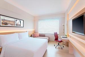 Habitación de hotel con cama blanca y TV en Fairfield by Marriott Lucknow, en Lucknow