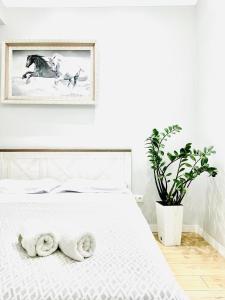 Un dormitorio con una cama blanca con toallas. en Seven hills, en Almaty