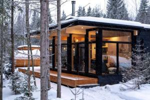 una casa nel bosco nella neve di ONИEA l Sauna & Spa a Petite-Rivière-Saint-François