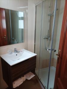 uma casa de banho com um lavatório e um chuveiro em Hostal San Cayetano em Ronda