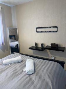 Stylish 4-Bedroom House near NEC/BHX في سوليهال: غرفة نوم عليها سرير وفوط