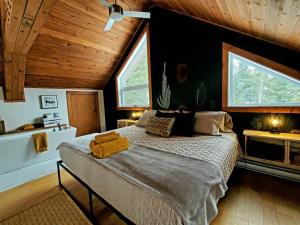 um quarto com uma cama grande e 2 janelas em Le Western : Spa l Sauna l Bar l Billlard em Valcartier Station