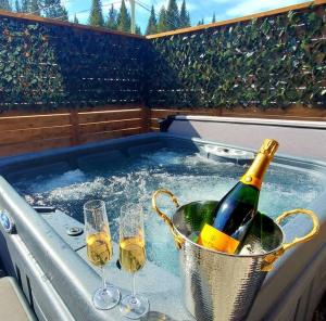 uma banheira de hidromassagem com taças de vinho e uma garrafa de champanhe em Le Western : Spa l Sauna l Bar l Billlard em Valcartier Station