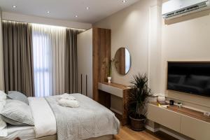 a bedroom with a bed and a flat screen tv at ProGarden Luxury Apartments Tirana in Tirana