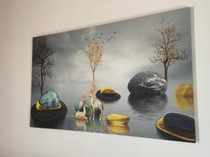 a painting of rocks and trees in the water at Yard Paradise Rooms Dhermi in Dhërmi