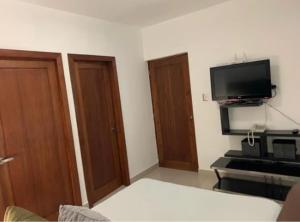 um quarto com duas portas e uma televisão na parede em Moderno practico y tranquilo em Santo Domingo