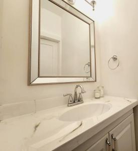 W białej łazience znajduje się umywalka i lustro. w obiekcie Old Quebec - Les Suites Montcalm - Free Parking w mieście Quebec City