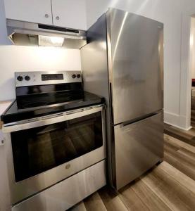 Il comprend une cuisine équipée d'une cuisinière en acier inoxydable et d'un réfrigérateur. dans l'établissement Old Quebec - Les Suites Montcalm - Free Parking, à Québec