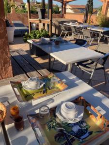two tables with dishes on them on a patio at Hôtel Le Gambetta in Vias