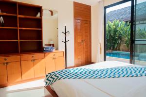 a bedroom with a bed and a dresser and a window at Near beach 3bedroom pool villa.（Rawai VIP B6） in Rawai Beach +91 photos