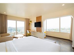 um quarto de hotel com uma cama grande e uma televisão em Bloom Hotel - Dona Paula em Panaji