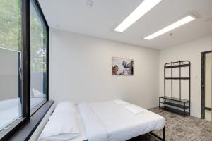 a bedroom with a bed and a large window at Trademark Hostel Sydney in Sydney