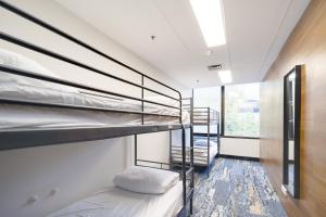 a room with two bunk beds and a window at Trademark Hostel Sydney in Sydney