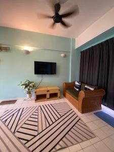 een woonkamer met een bank en een plafondventilator bij Lovly Couple Sea View w Netflix in Port Dickson