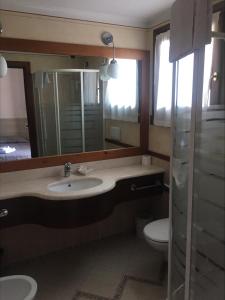 a bathroom with a sink and a toilet and a mirror at Le Corti Del Lago in Padenghe sul Garda