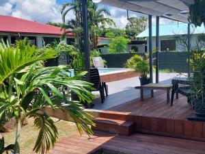 una terraza de madera con un banco y una mesa en "Koko Lodge" Lodge paisible avec terrasse, jardin et piscine, en Rémiré