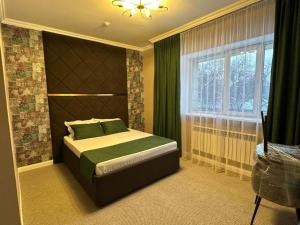 a bedroom with a bed and a window at Grand Bereke Hotel in Almaty