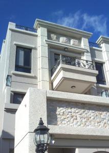 een wit gebouw met een balkon en een straatlicht bij Hualien Edinburgh Homestay in Hualien