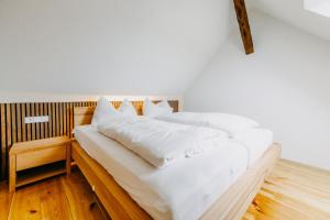 ein großes weißes Bett mit weißer Bettwäsche und Kissen in der Unterkunft Urlaub im Kellerstöckl Dunst in Strem