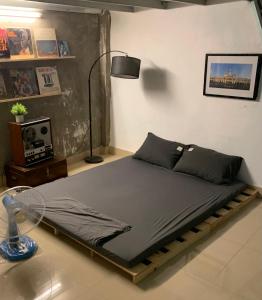 Bett in einem Zimmer mit Ventilator und Lampe in der Unterkunft The Vinyl Homestay in Ho-Chi-Minh-Stadt