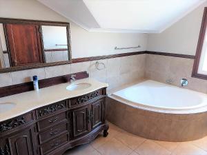 een badkamer met een bad, een wastafel en een bad bij 3 Rawdons Estate in Nottingham Road
