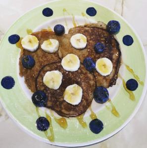 a plate with a pancake with bananas and blueberries at Errisbeg Lodge Bed + Breakfast in Roundstone