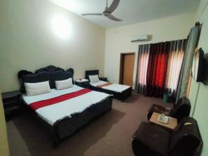 ein Schlafzimmer mit einem Bett und einem Stuhl in einem Zimmer in der Unterkunft Peridot Cottage in Islamabad