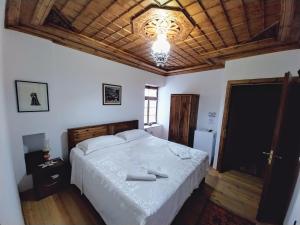 um quarto com uma cama grande e um tecto de madeira em Guest House J.Prifti em Berati
